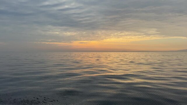 夕焼けに染まる海を水しぶきを上げながらボートで疾走する