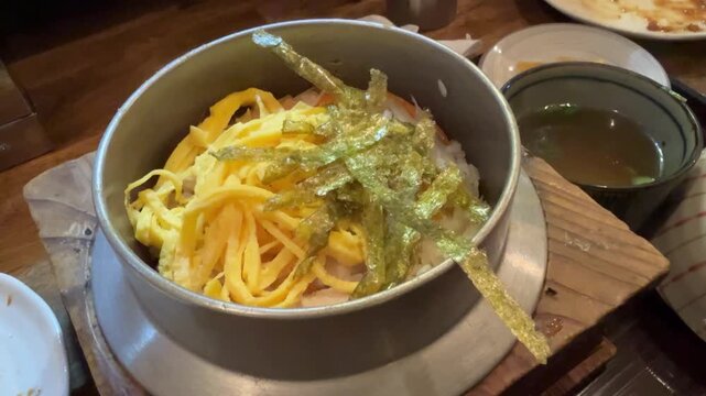 錦糸卵と海苔がのった釜飯の蓋を取る