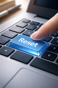 Finger pressing reset key on computer keyboard close up