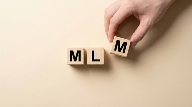 A hand places a wooden block with the letter m to complete the mlm acronym on a soft neutral background for business concept