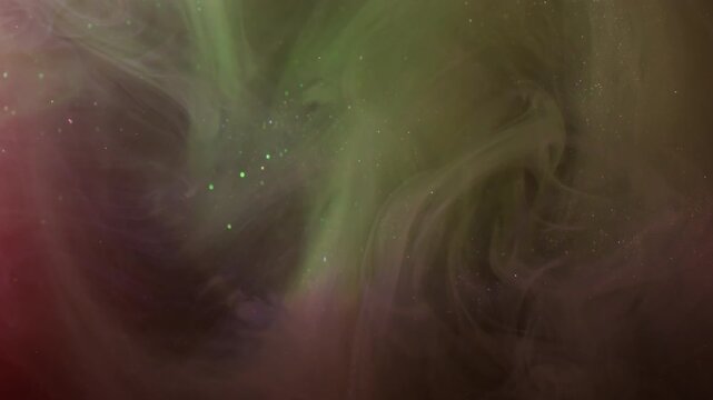 Paint blend. Ink background. Defocused pink yellow color cloud sparkling splash liquid texture spreading on dark black acrylic abstraction.