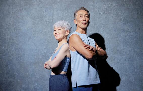 スポーツウェアを着たシニア男性と女性　ポートレート　黒背景