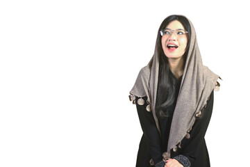Naklejka premium Young woman wears hijab and glasses. She smiles warmly with joyful expression. Her eyes sparkle with happiness and surprise. Bright white background emphasizes her cheerful face