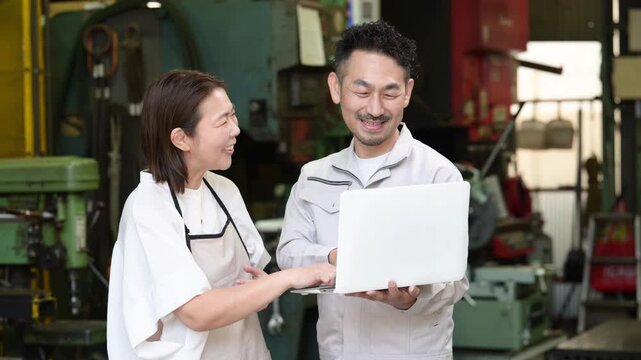 工場でノートパソコンを確認する夫婦のDX活用、itやAI化の業務効率化で成長や成功するポジティブな笑顔のイメージの動画