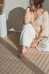 Fototapeta premium A woman doing yoga in her living room (relaxation, healthcare, meditation)