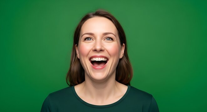 Joyful Young Woman Laughing Heartily With Eyes Closed in Genuine Expression of Happiness and Amusement her Face Radiating Positive Emotion and Delight Against a Vivid Green Backdrop Showing a