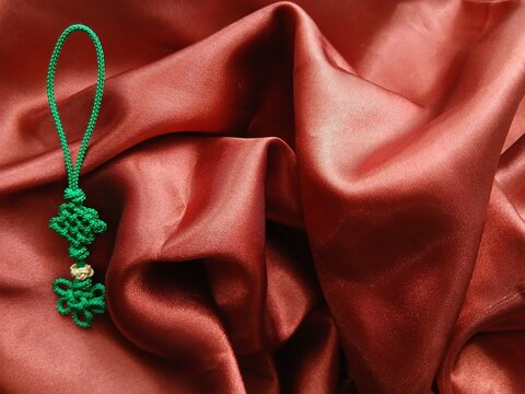 Traditional Korean handmade colorful knots decoration on undulating satin wrapping cloth (Silk-like wrapping cloth) 