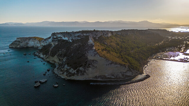 Aerial panoramic view of the massive Sella del Diavolo limestone headland and Calamosca marina at sunset, Cagliari, Sardinia, Italy