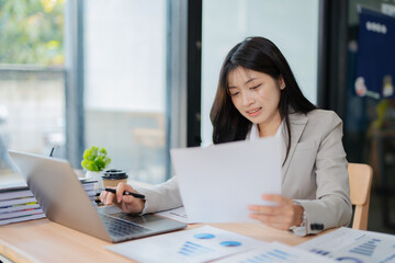 Fototapeta premium Accountant woman working on financial investment on calculator, calculation, business growth analysis and marketing on graph at office.