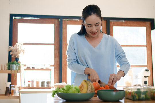 Preparing fresh vegetables by slicing carrot for healthy home cooking