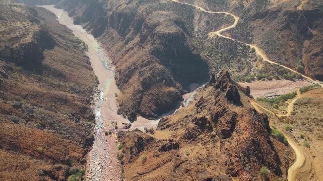 Drone view of arid canyon river and winding dirt road. Wadi Dirhur, Sokotra, Yemen.