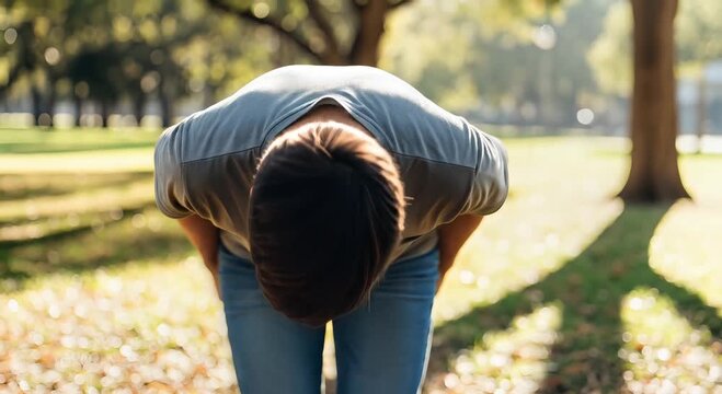 outdoor park stretch: person bending forward in sunlight