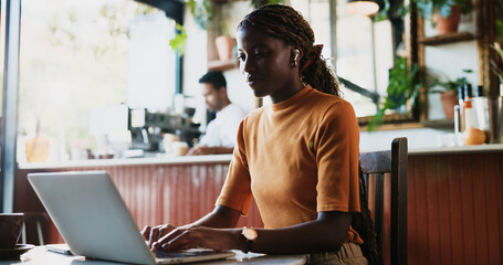Woman, student and laptop in coffee shop for studying, assignment review and schedule update. Typing, person and computer in cafe for assessment planning, research and essay draft for submission