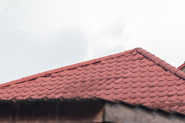 Naklejka premium Red Clay Tile Roof Against Bright Sky Background with Copy Space