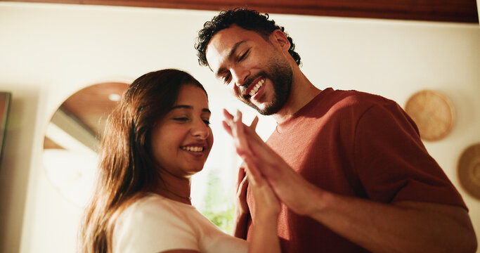 Happy, couple and holding hands in home with love, romantic connection or bonding together on weekend. People, smile and affection in living room with marriage commitment, loyalty or care for partner