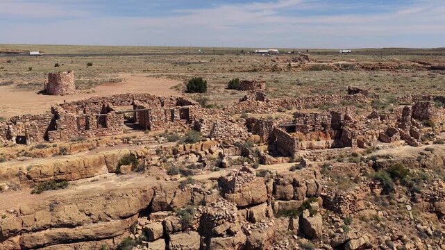 This drone shot approaches a remote historical site featuring ruined stone fortifications. The high desert landscape provides an epic background for travel and archaeological discovery content.