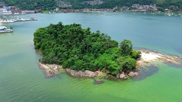 Ilha do Coqueiro near Praia do Anil in Angra dos Reis Rio de Janeiro Brazil with dense Atlantic Forest vegetation and rocky shoreline within Ba&iacute;a da Ilha Grande, drone orbit establishing shot