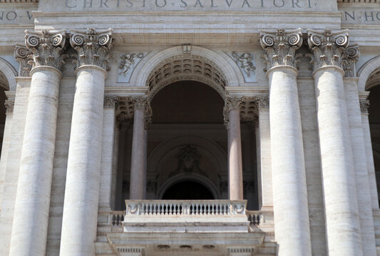 Dettaglio della loggia centrale e delle colonne corinzie della facciata di San Giovanni in Laterano a Roma, maestosa architettura tardo barocca con capitelli decorati e balaustra in marmo