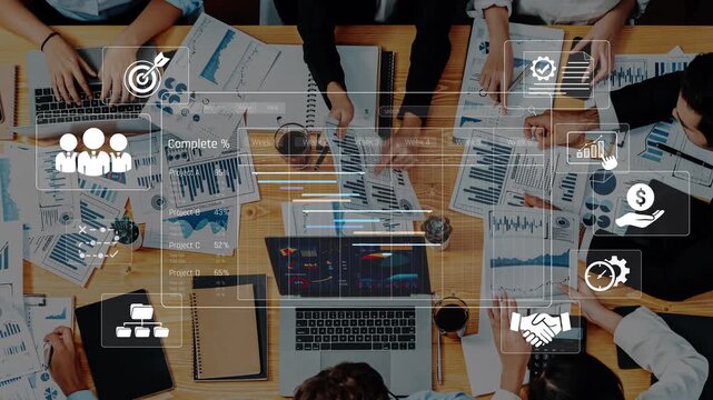 A diverse group of professionals collaborates on data analysis, surrounded by charts and graphs, highlighting teamwork and strategic planning in a modern office setting. Raster