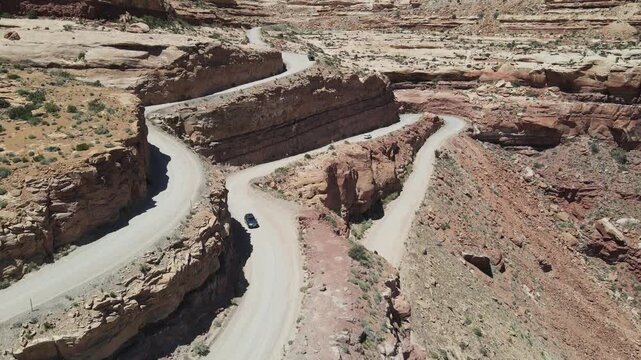 Cinematic 4K drone footage featuring a dynamic forward flight directly above the winding Moki Dugway switchbacks (Highway 261) in the Utah desert.