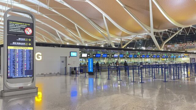 Shanghai Pudong International Airport, Shanghai, China, March 30, 2026: interior view of the check-in area featuring flight information displays and empty counters.