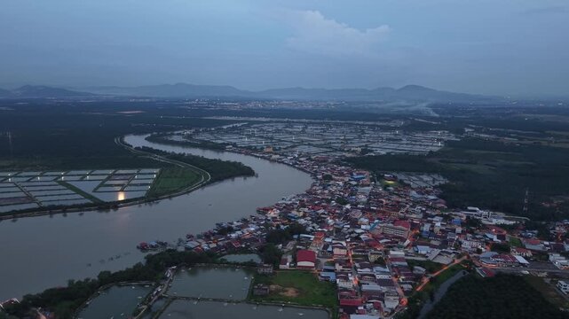 Nighttime aerial footage of Sungai Udang village along a winding river with surrounding fish ponds.