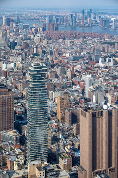 Aerial view of the modern 56 Leonard Street skyscraper and the dense urban architecture of Lower Manhattan with the East River in the distance in New York, New York, United States.