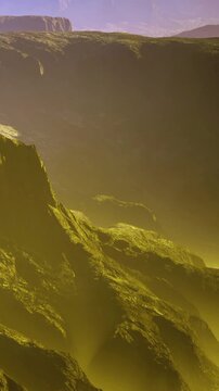 Rock formations rise in layers under a sunset sky. Shadows fall over the rugged terrain. The scene shows the natural beauty of the landscape. Light creates contrast across the rocks.