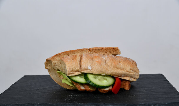Frisch belegtes Sandwich mit Gem&uuml;se Bulette Fleisch &ndash; Snack to go, gesund, knuspriges Brot, Mittagessen, Takeaway, Foodfotografie, minimalistisch, Copyspace, isoliert
