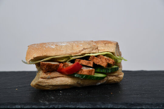 Frisch belegtes Sandwich mit Gem&uuml;se Bulette Fleisch &ndash; Snack to go, gesund, knuspriges Brot, Mittagessen, Takeaway, Foodfotografie, minimalistisch, Copyspace, isoliert