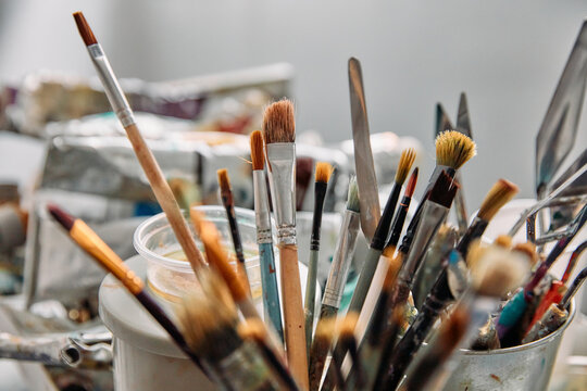 Collection of Professional Artist Paintbrushes and Palette Knives in a Studio