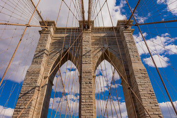 Obraz premium Majestic Brooklyn Bridge stands tall against a vivid blue sky in New York