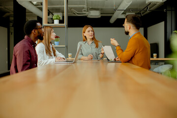 Obraz premium Engaging team discussion in modern workspace at midday meeting