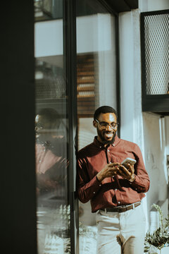 Man in stylish shirt enjoying coffee while texting in modern cafe