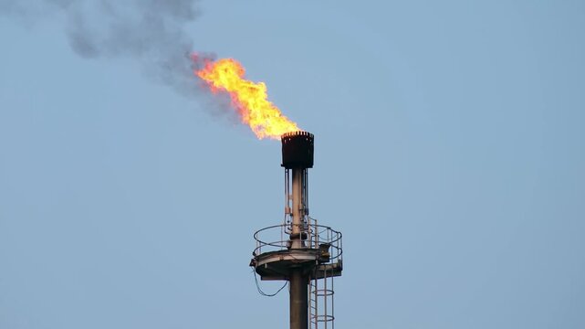Industrial flare stack burning off excess gas.