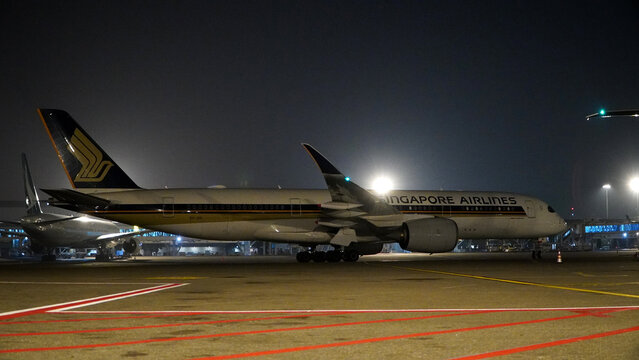 Close up view of a commercial aircraft Singapore Airlineswing and engine under bright airport floodlights during nighttime on April 22, 2026 in Soekarno-Hatta Interational Airport, Jakarta, Indonesia.