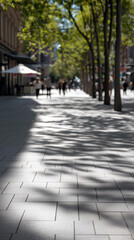 Obraz premium Sunlit Downtown Street During Heatwave, Pedestrians Strolling Between Cafes And Trees, Long Crisp Shadows On Patterned Pavement, Warm Highlights And Soft Bokeh, Relaxed Summer Commute Atmosphere