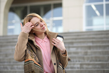 Fototapeta premium Cute blonde in the city drinking coffee