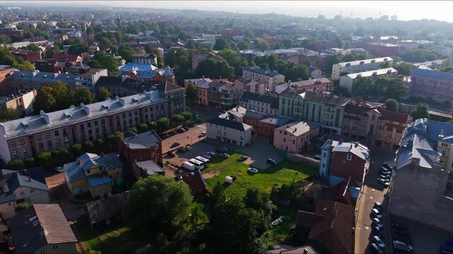 Tilt down aerial over Liepaja old town reveals houses courtyard and streets