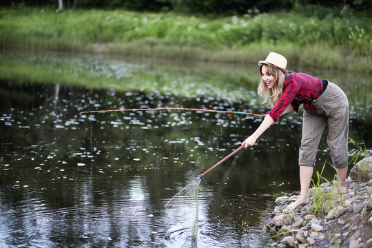 Girl by the river with a fishing rod