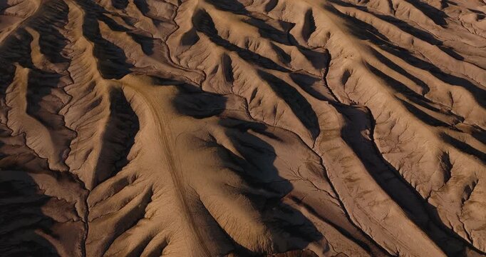 Aerial patterns of winding erosion ridges across dry Utah desert badlands terrain, clean extraterrestrial landscape background