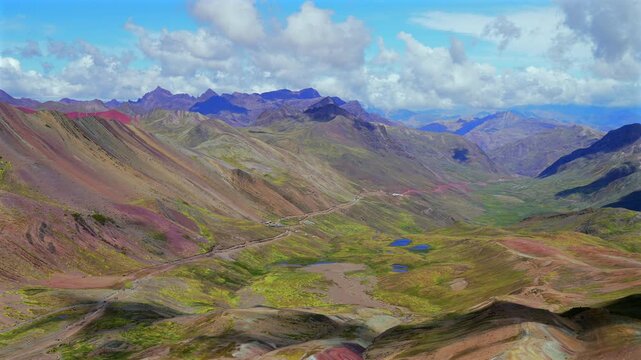 Peruvian Andes Vinicunca Rainbow Mountain stunning 4wd valley panorama scenery landscape Peru's Vilcanota Range mountains near Ausangate Glacier Quelccaya Ice Caps sunny blue sky morning clouds pan
