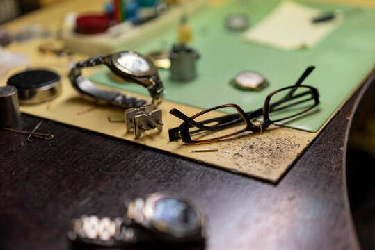 disassembled wristwatch and spectacles