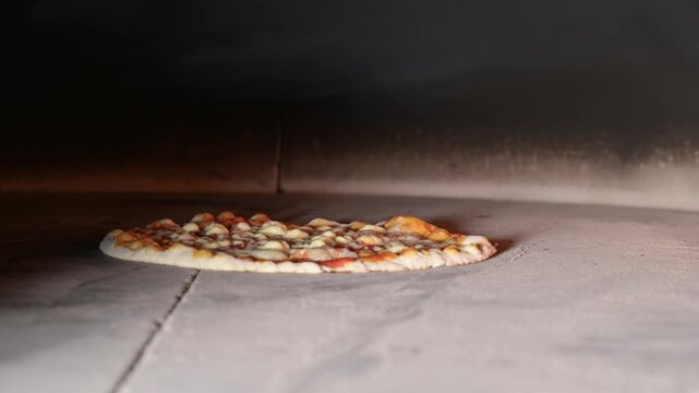 classic Margherita pizza baking inside a rotating wood-fired oven. Flames flicker around the edges as the dough rises and the mozzarella melts into the rich tomato sauce