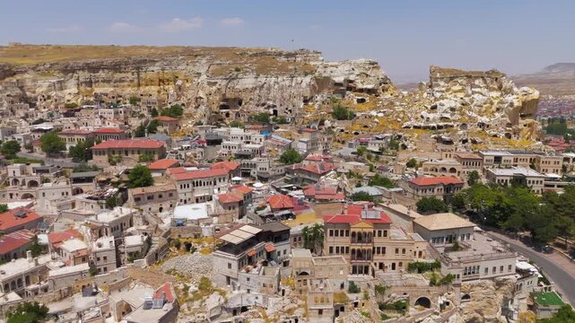 Urgup, Nevsehir, Turkey. Traditional houses against rocky cliff background with ancient dwellings in Cappadocia.. Aerial View
