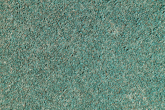 Textura de superficie de caucho granulado de color verde azulado para parques infantiles.