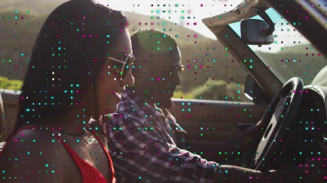 Driver lowering map onto dash after glancing forward, woman adjusting sunglasses for travel