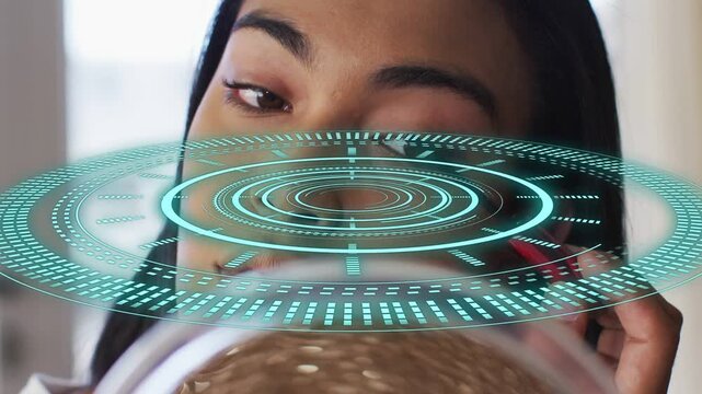 Woman raising mirror, moving mascara wand to right eye with teal beauty HUD pulsing over mirror
