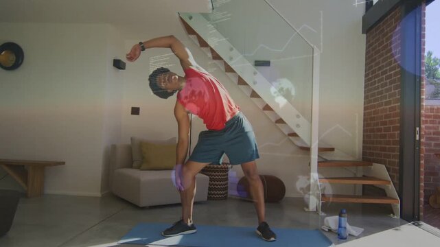 Man doing side-stretch on blue mat at home, following fitness tracker prompt, showing lens flares