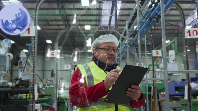 Senior supervisor noting on clip and walking plant floor, with AR globe appearing, ensuring quality